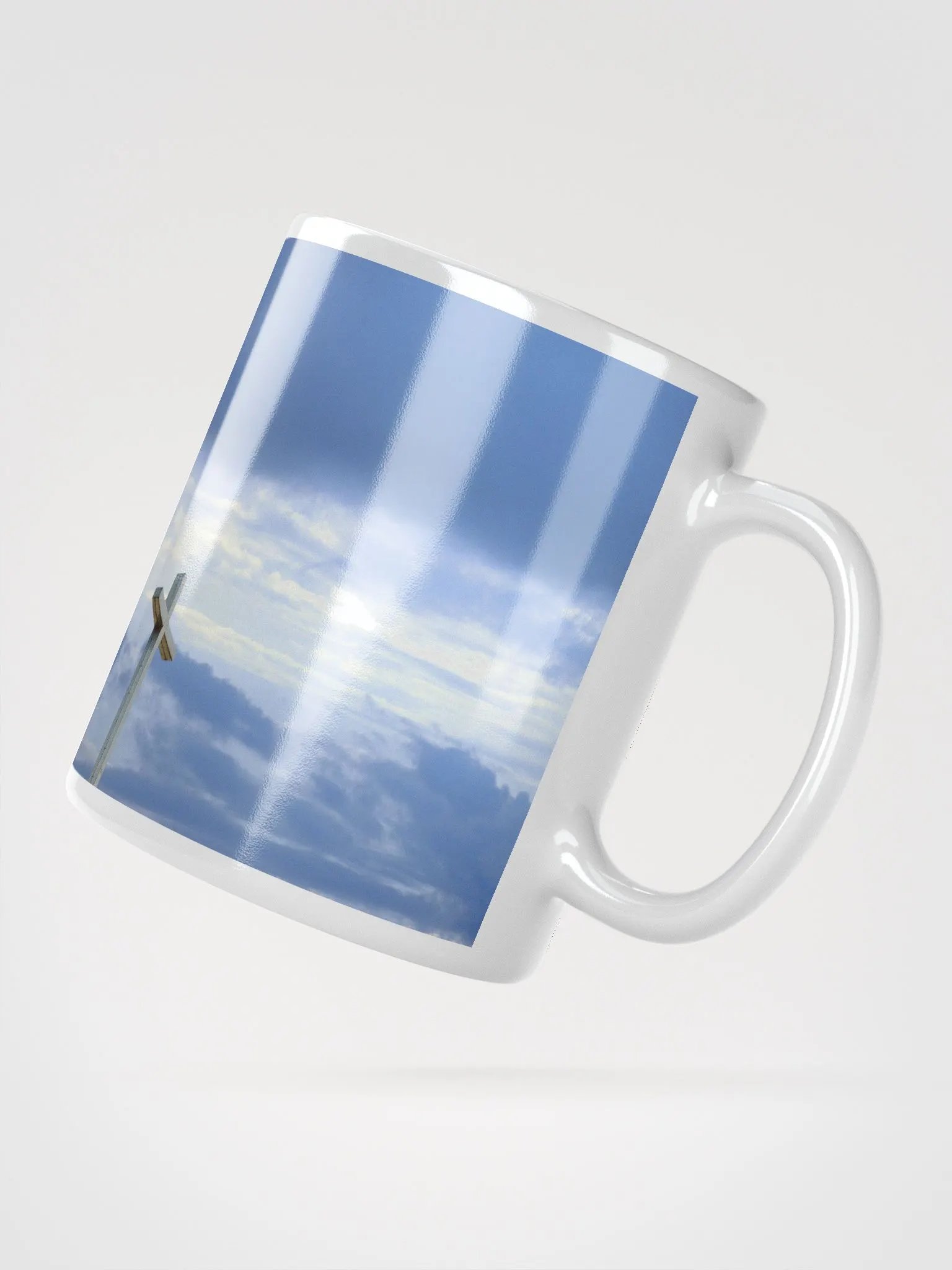 Wooden cross standing atop a rocky hill or mountain, under a sky filled with soft clouds & warm sunlight & cross standing against a dramatic sky with layers of clouds Mug product image (4)