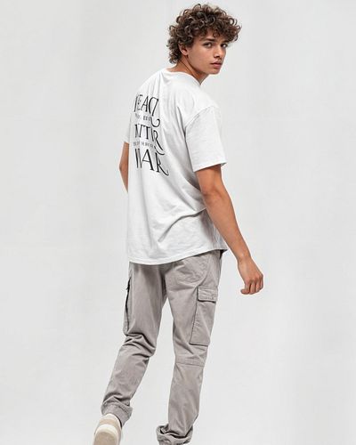 This stylish t-shirt features a bold peace symbol on the front, making a statement of unity and hope. The back of the shirt c...