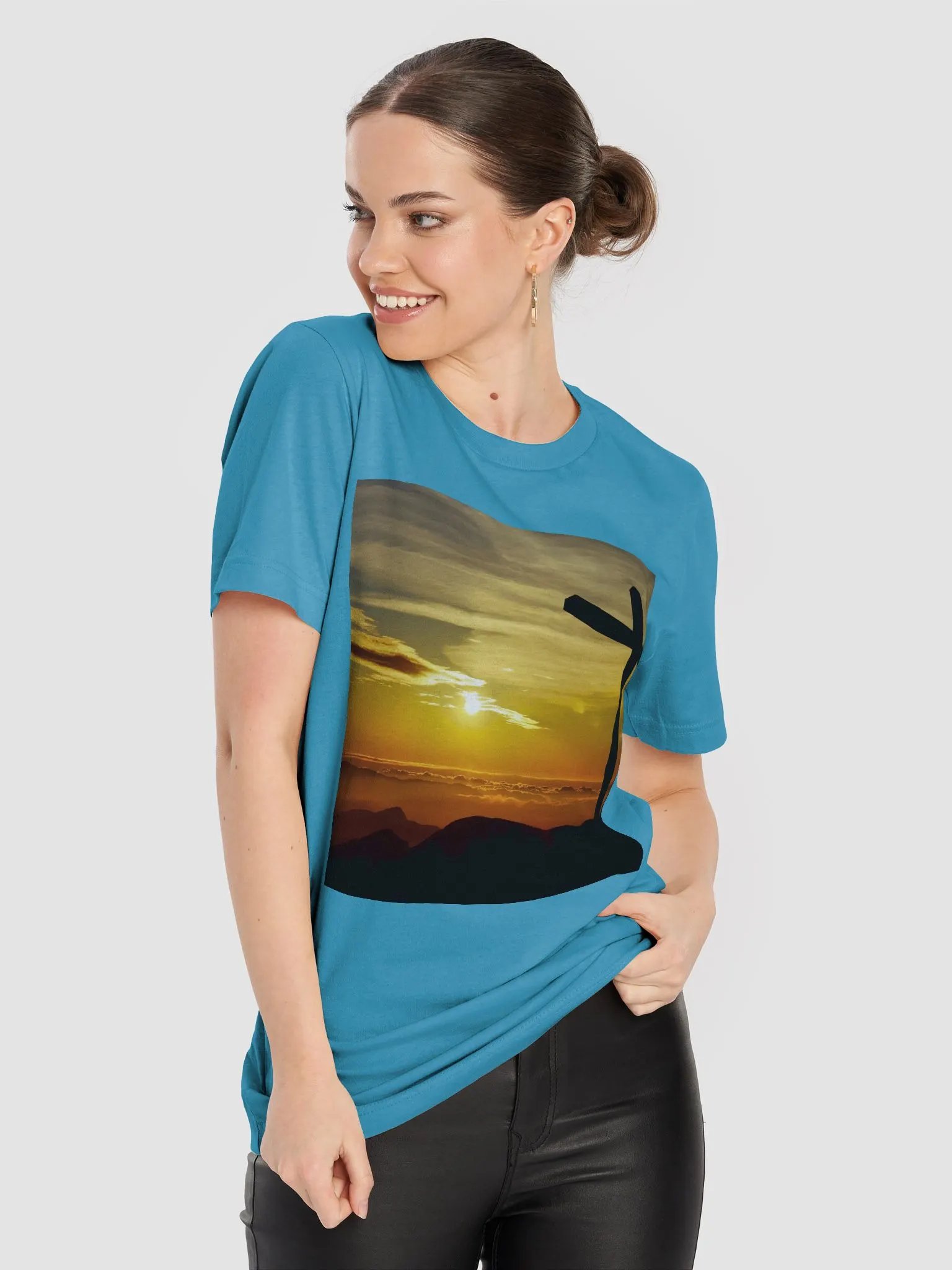 Large cross silhouetted against a dramatic sunset, vibrant hues of yellow, orange, dominate the sky, with clouds and distant mountains t-shirt product image (6)