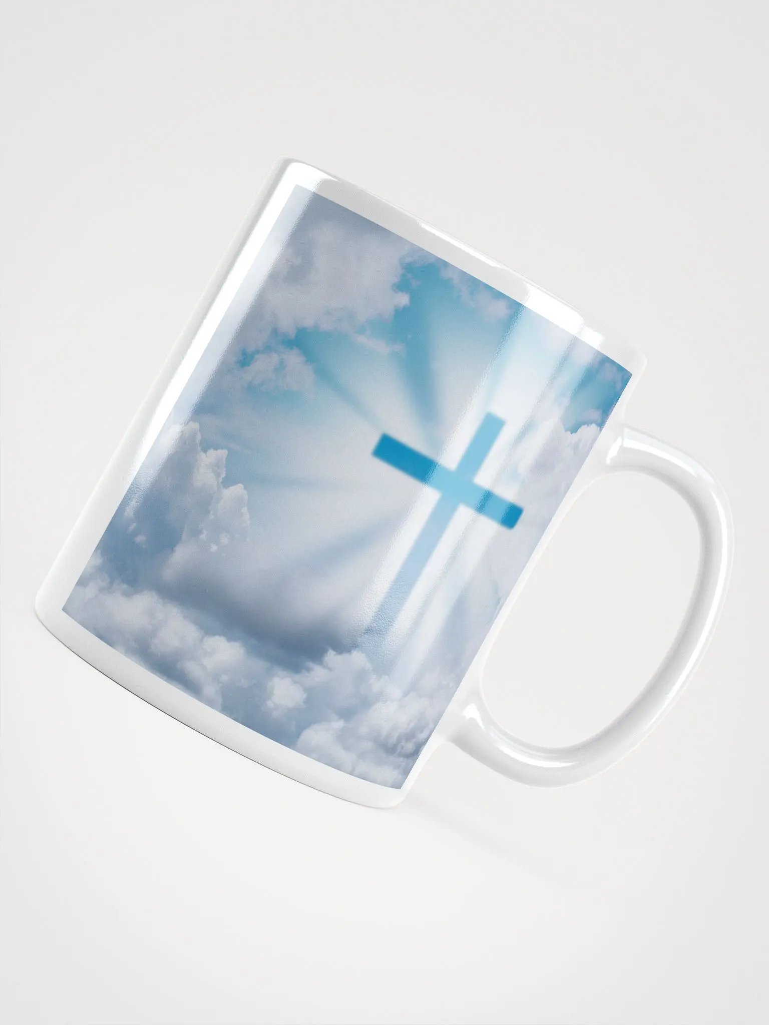 Glowing cross illuminated by intense golden light & a cross surrounded by a heavenly scene, with rays of light shining through soft clouds in a bright blue sky Mug product image (2)