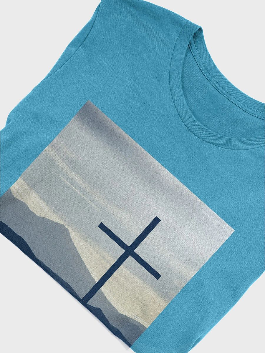 A cross standing against a serene landscape of rolling hills and distant mountains under a soft, cloudy sky t-shirt product image (9)