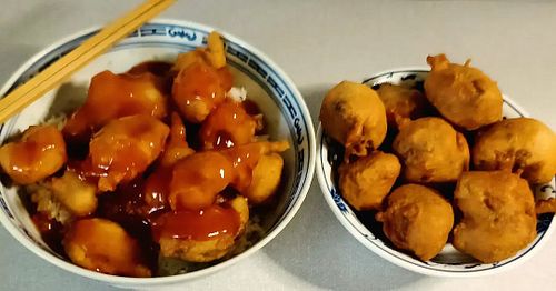 Sweet and sour prawns over rice next to crispy chicken balls