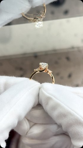 A fully custom three-stone ring made in 14K yellow gold, showcasing an 2.03ct oval center stone flanked by two pear-shaped di...