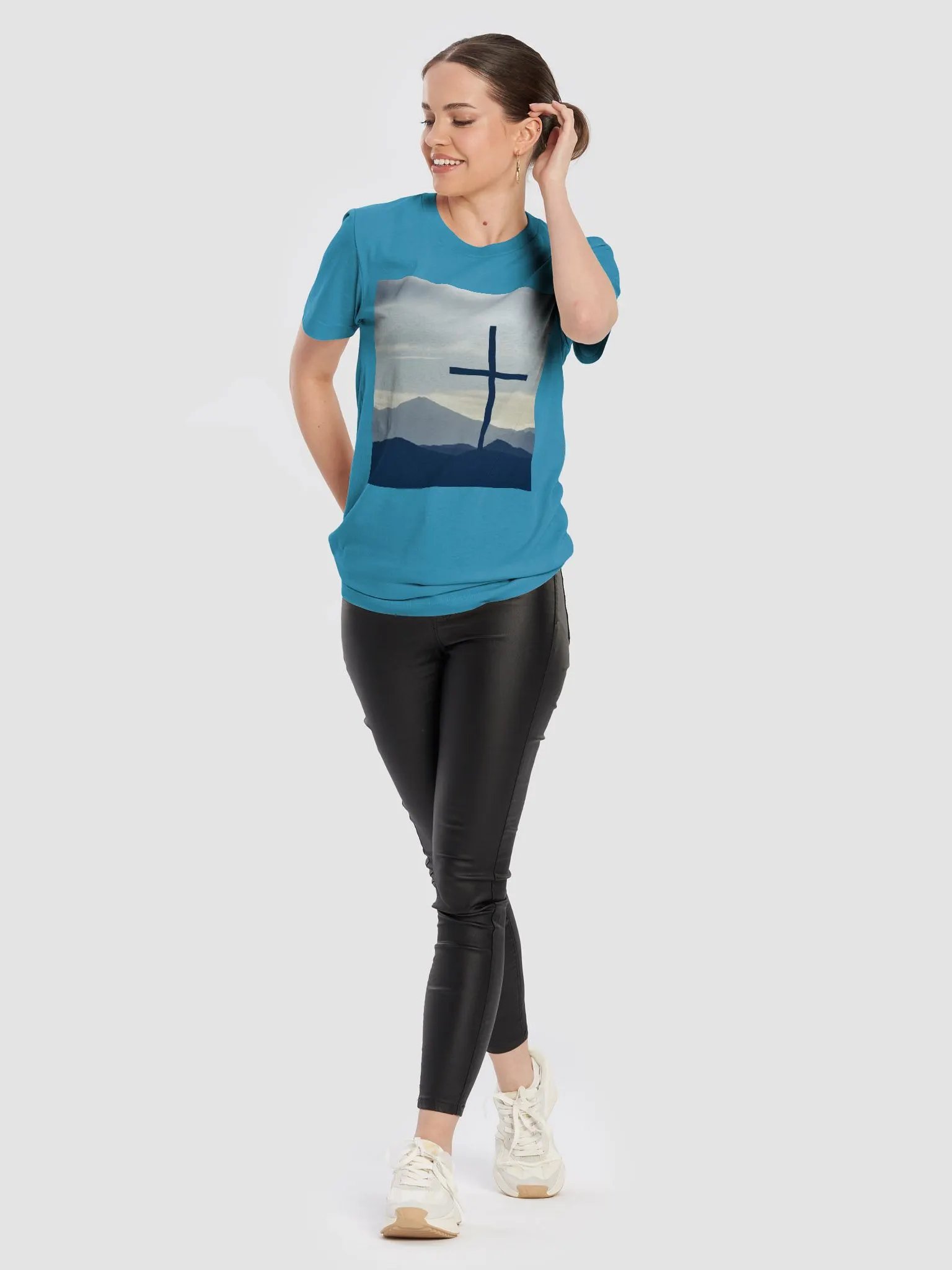 A cross standing against a serene landscape of rolling hills and distant mountains under a soft, cloudy sky t-shirt product image (2)