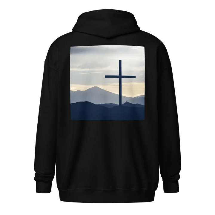 A cross standing against a serene landscape of rolling hills and distant mountains under a soft, cloudy sky Hoodie product image (1)