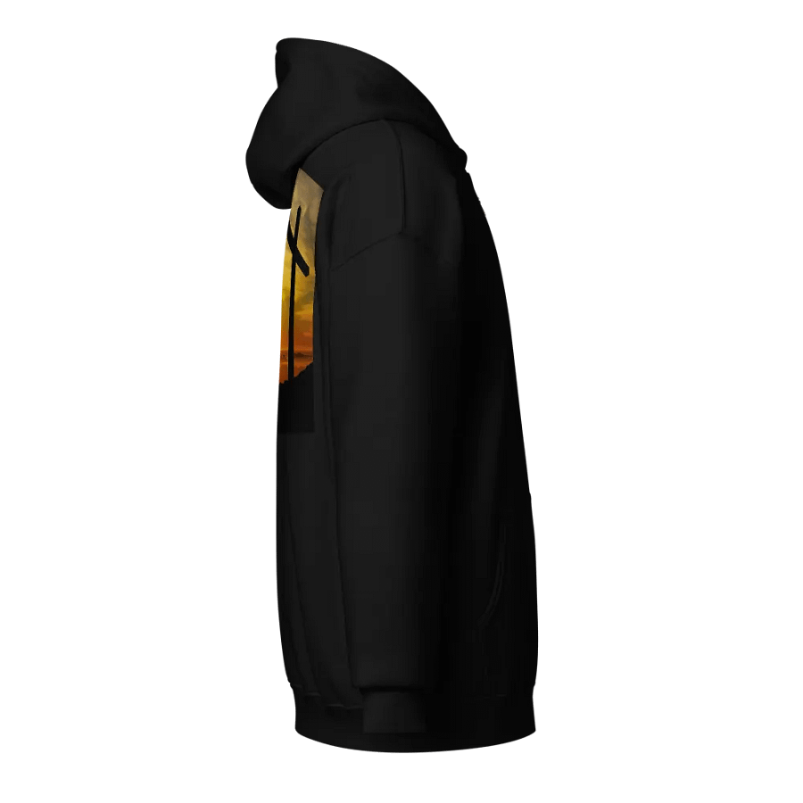 Large cross silhouetted against a dramatic sunset, vibrant hues of yellow, orange, dominate the sky, with clouds and distant mountains Hoodie product image (4)