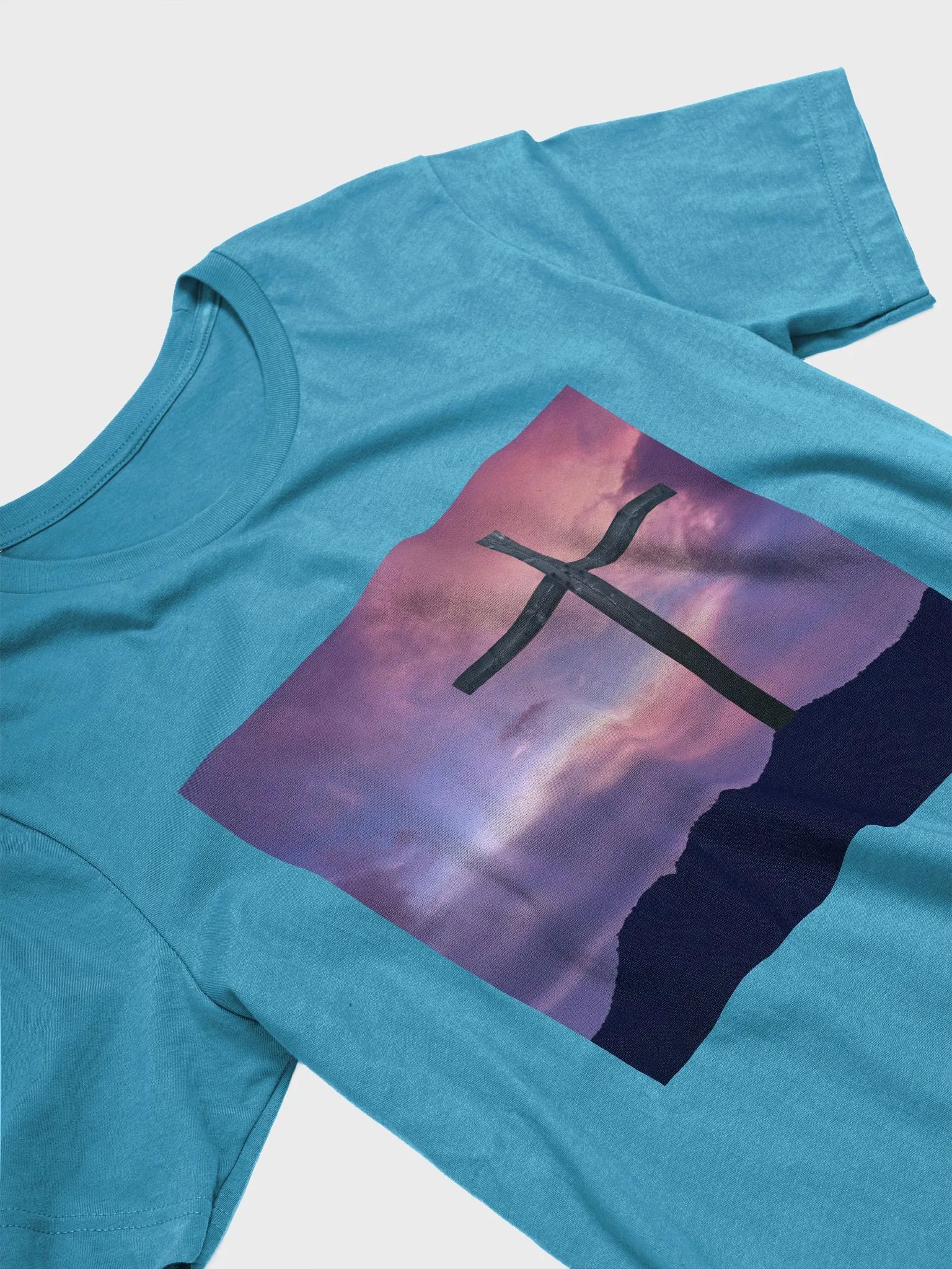 Wooden cross standing on a hill, silhouetted against a vibrant and colorful sky transitioning from deep purples to pinks t-shirt product image (10)