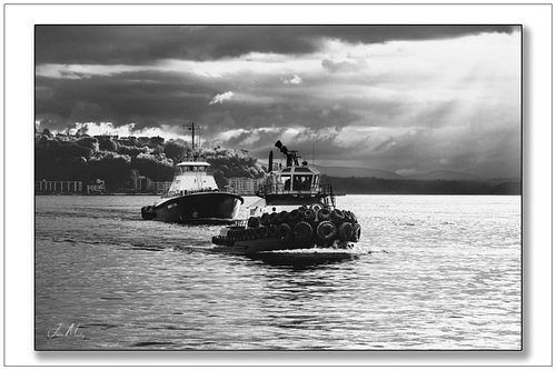 Two Foss tugs cutting through the waters of Seattle, framed by dramatic skies and the quiet strength of the Northwest. These ...