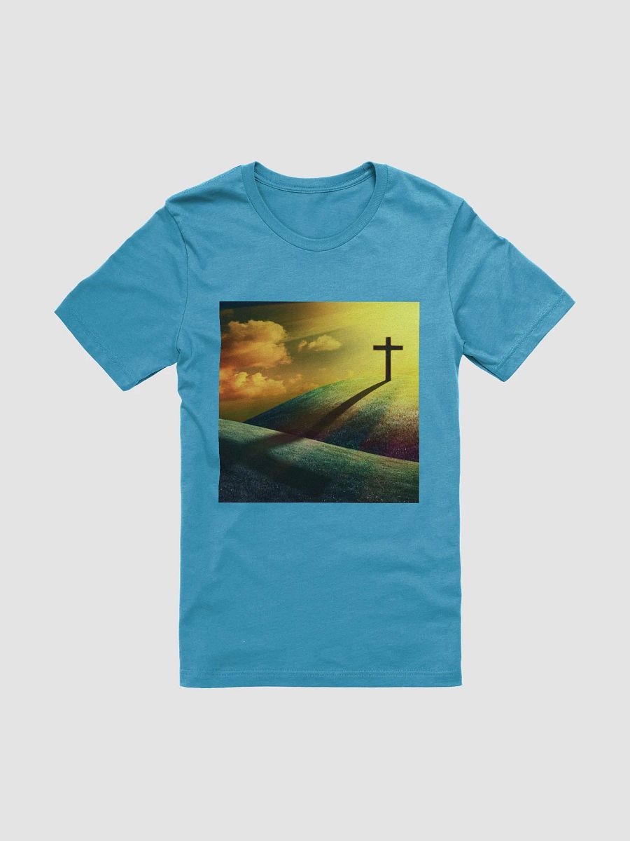 A cross standing prominently on a grassy hill, with a vivid, dramatic background t-shirt product image (1)