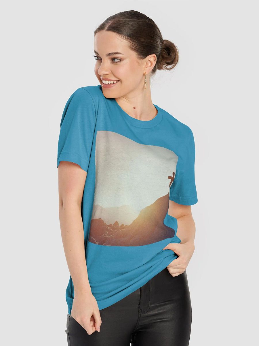A cross placed on top of a rocky hill, bathed in the warm glow of a sunrise or sunset t-shirt product image (6)