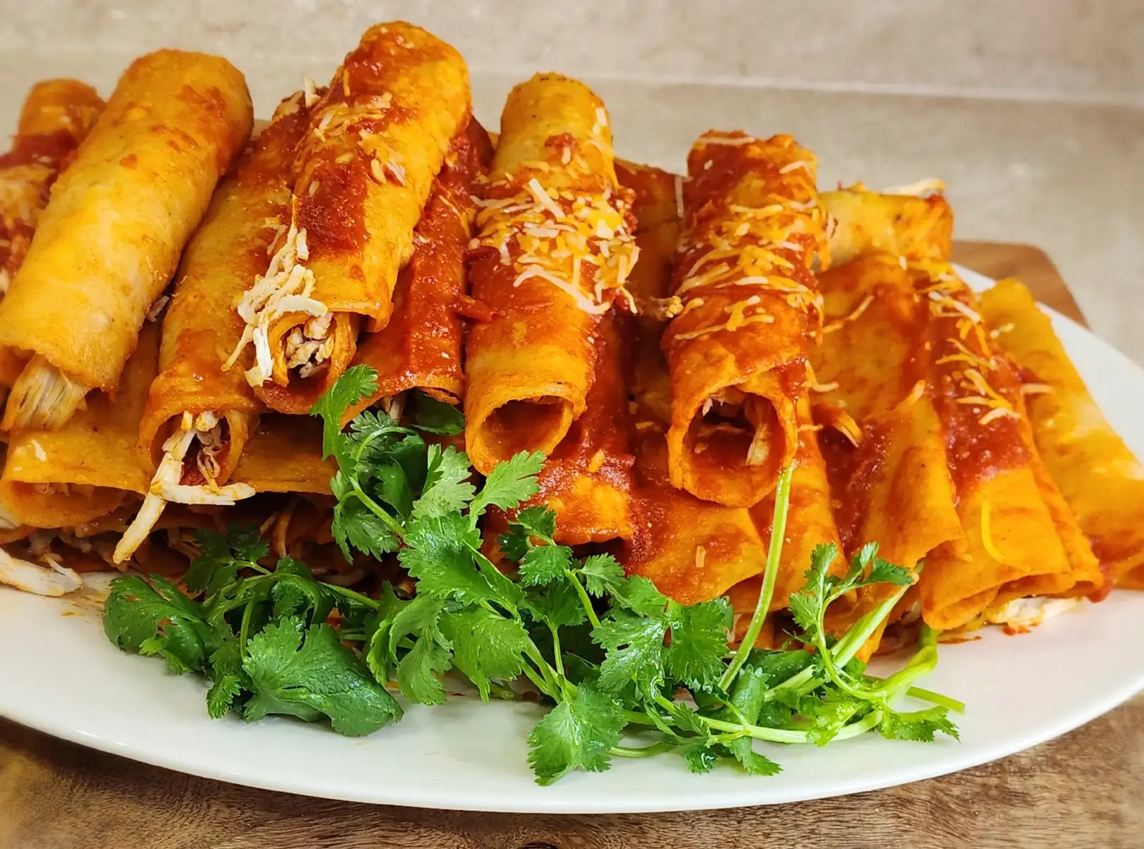 Ingredientes  * 13 jitomates roma  * 8-9 chiles guajillos  * 9 chiles de árbol  * 1/2 cebolla  * 5 dientes de ajo  * 1 tomatillo grande (verde)  * 25 tortillas de maíz  * 3 pechugas de pollo cocidas y desmenuzadas  * 2 tazas de queso revuelto estilo mexicano o tu queso preferido, rallado  * Caldo de pollo (el necesario para cocer las pechugas y para moler los ingredientes)  * Aceite vegetal (para freír)  * Sal al gusto Preparación Paso 1: Cocer el Pollo  * En una olla, cuece las pechugas de pollo con suficiente agua y un poco de sal o Knorr, 3 dientes de ajo, 1/2 cebolla hasta que estén bien cocidas. Una vez listas, retira el pollo, desmenuza y reserva. Guarda el caldo de pollo, lo usarás más adelante. Paso 2: Preparar los Aromáticos y Jitomates  * En un sartén grande (donde vas a preparar la salsa), calienta un poco de aceite.  * Fríe los 5 dientes de ajo y la 1/2 cebolla picada hasta que estén ligeramente dorados y fragantes.  * Agrega los 13 jitomates y el 1 tomatillo (pueden ir cortados en cuartos o a la mitad para facilitar la cocción). Fríelos junto con el ajo y la cebolla por unos 15 minutos, hasta que los jitomates estén suaves.  * Retira los jitomates, ajos y cebolla del sartén y reserva. No limpies el sartén, lo usarás para los chiles. Paso 3: Preparar los Chiles  * En el mismo sartén donde freíste los jitomates, agrega un poco más de aceite si es necesario.  * Fríe ligeramente los chiles guajillos y los chiles de árbol por unos segundos, teniendo cuidado de que no se quemen para evitar un sabor amargo.  * Inmediatamente después de freír, agrega un poco del caldo de pollo caliente a los chiles en el sartén para que se ablanden. Deja reposar por unos minutos. Retira los chiles y reserva por separado. Paso 4: Moler la Salsa Roja  * En la licuadora, muele los jitomates, ajos y cebolla que reservaste, utilizando caldo de pollo para lograr una consistencia tersa.  * En otra tanda, muele los chiles guajillos y de árbol ablandados, también con caldo de pollo.  * Cuela la mezcla de chiles para eliminar cualquier pellejo o semilla restante. Paso 5: Cocinar la Salsa  * En el sartén donde preparaste los jitomates y chiles, vierte la salsa de jitomate, ajo y cebolla. Lleva a ebullición.  * Incorpora la salsa de chiles colada al sartén con la salsa de jitomate. Mezcla bien y deja que la salsa hierva a fuego medio-bajo por unos 10-15 minutos, revolviendo ocasionalmente, hasta que espese ligeramente y los sabores se integren. Sazona con sal al gusto. Paso 6: Freír las Tortillas  * En un sartén aparte, calienta suficiente aceite para freír las tortillas de maíz.  * Fríe las 25 tortillas una por una, solo unos segundos por cada lado, hasta que estén suaves y ligeramente flexibles, no crujientes. Retira el exceso de aceite colocando las tortillas sobre papel absorbente. Paso 7: Armar las Enchiladas  * Una vez que tengas todas las tortillas fritas, sumerge de 5 en 5 las tortillas en la salsa caliente por unos segundos, asegurándote de que se impregnen bien.  * Con unas pinzas, saca las tortillas de la salsa y colócalas extendidas en un plato grande.  * Rellena cada tortilla con una porción de pollo desmenuzado y, si lo deseas, un poco de queso.  * Enrolla las tortillas y acomódalas en un platón o directamente en los platos individuales.  * Cubre las enchiladas con más salsa caliente y espolvorea generosamente con el queso restante. ¡Disfruta tus enchiladas rojas hechas con tu toque personal!  #EnchiladasRojas #ComidaMexicana #RecetaMexicana #HechoEnCasa #CocinaTradicional #SaborCasero #EnchiladasDePollo #GastronomiaMexicana #Delicioso #MexicanFood