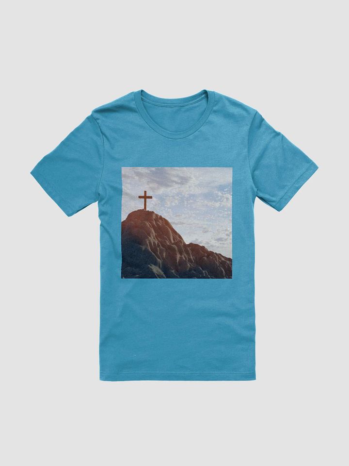 Wooden cross standing atop a rocky hill or mountain, under a sky filled with soft clouds and warm sunlight t-shirt product image (1)
