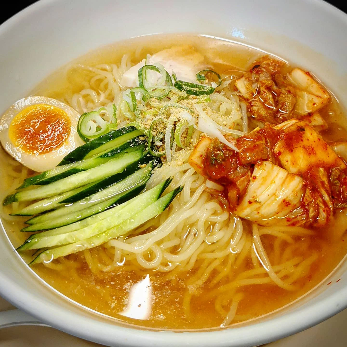 A bowl of cold reimen, a Morioka-style cold noodle dish, similar to some Korean cold noodle dishes. The noodles are very chew...