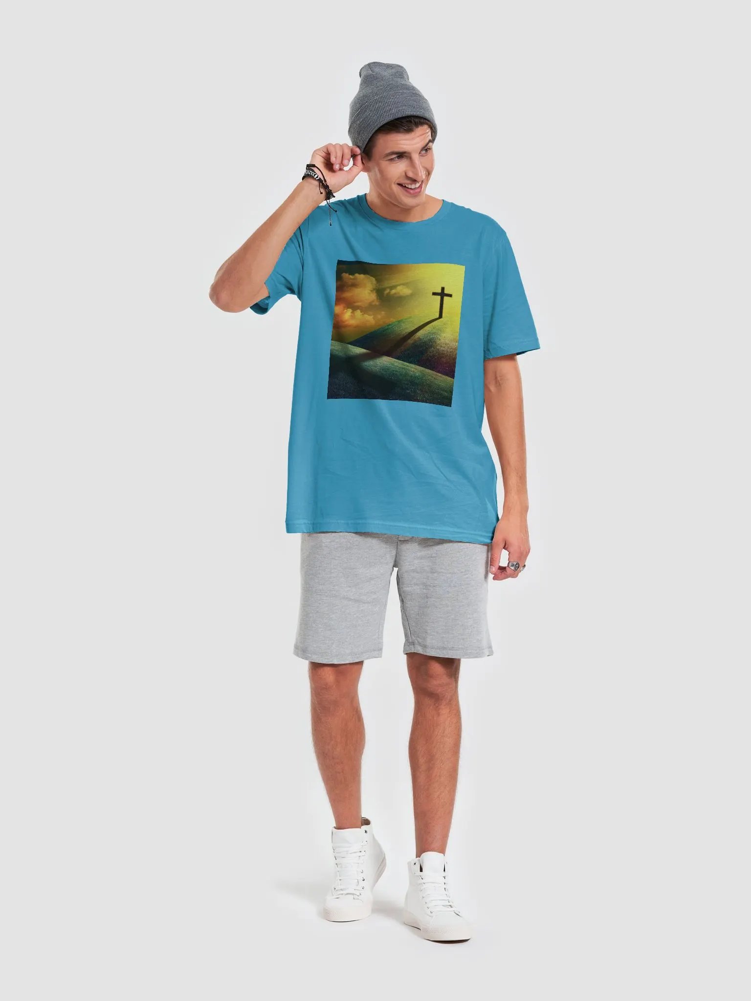 A cross standing prominently on a grassy hill, with a vivid, dramatic background t-shirt product image (8)